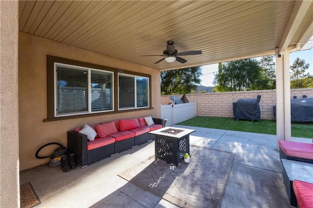 view of patio featuring ceiling fan and an outdoor living space with a fire pit