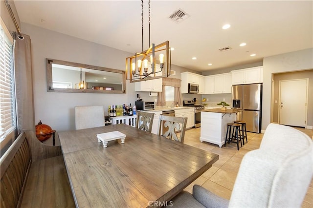 dining space featuring light tile patterned flooring and a chandelier