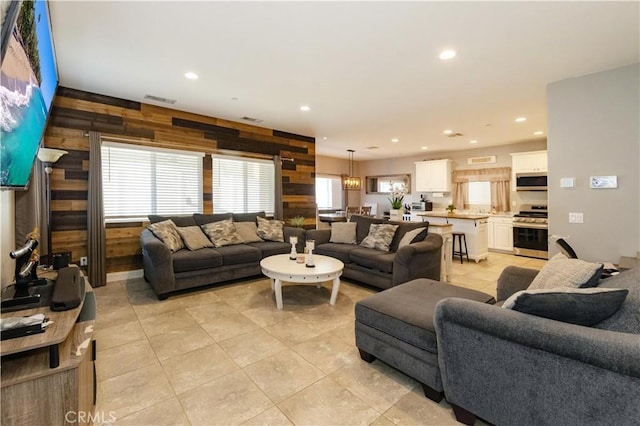 living room with wood walls and light tile patterned floors