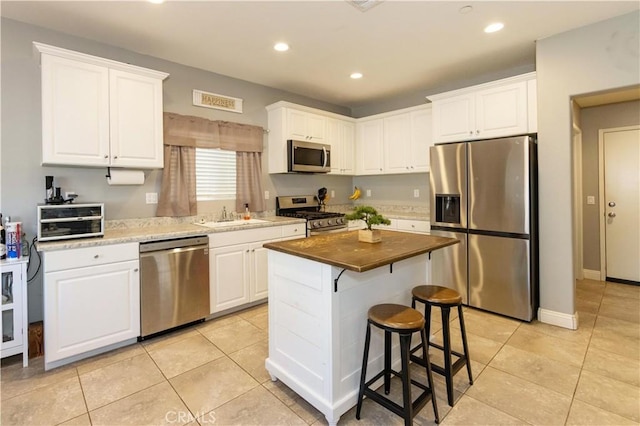 kitchen with white cabinets, stainless steel appliances, and a kitchen island