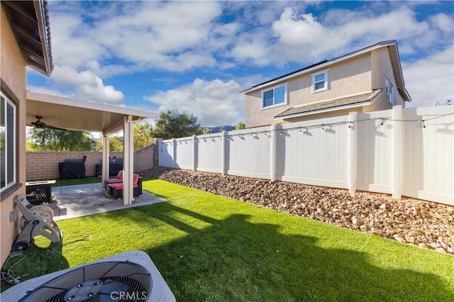 view of yard featuring central AC, ceiling fan, and a patio area