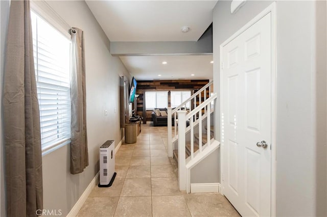 hall with light tile patterned floors and a wealth of natural light