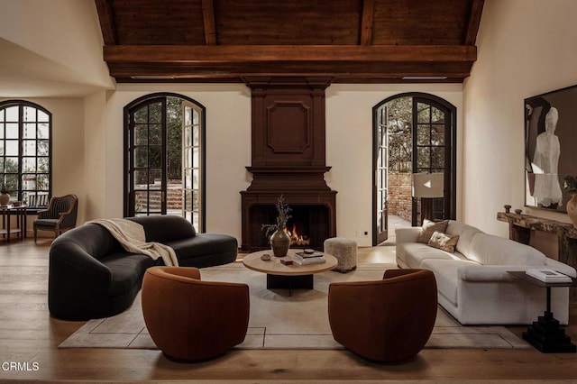 living room with beamed ceiling, light wood-type flooring, high vaulted ceiling, and wooden ceiling