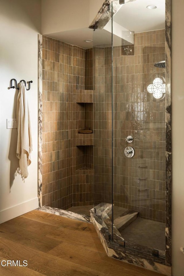 bathroom featuring a tile shower and hardwood / wood-style flooring