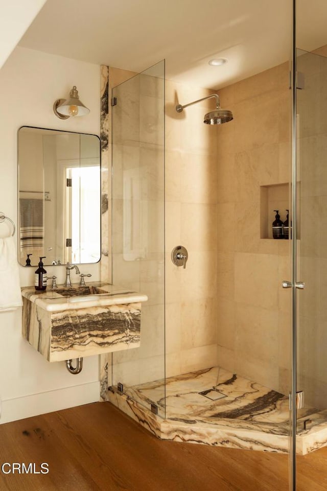 bathroom with hardwood / wood-style floors, sink, and walk in shower