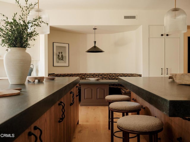 bar with pendant lighting and light hardwood / wood-style floors