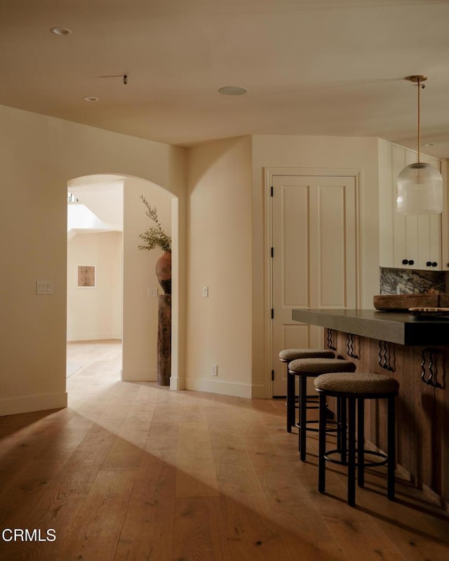 dining space with bar area and light wood-type flooring