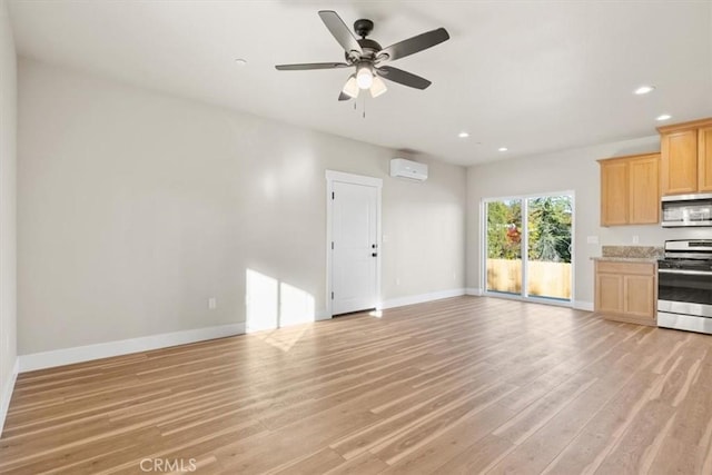 unfurnished living room with a wall mounted AC, ceiling fan, and light hardwood / wood-style floors