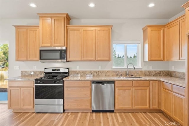 kitchen featuring sink, light wood-type flooring, light brown cabinets, and appliances with stainless steel finishes