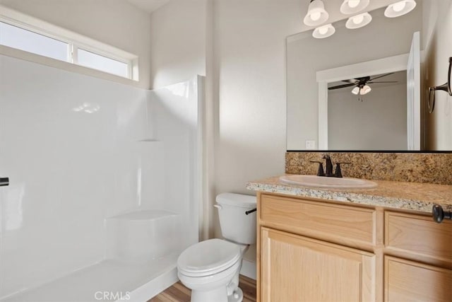 bathroom with ceiling fan, walk in shower, wood-type flooring, toilet, and vanity