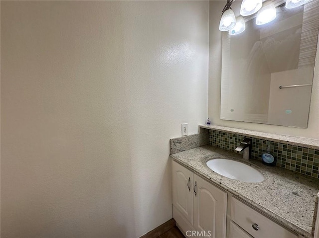 bathroom with decorative backsplash and vanity