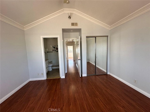 unfurnished bedroom with ensuite bath, dark hardwood / wood-style floors, crown molding, vaulted ceiling, and a closet