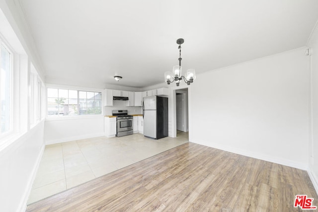 unfurnished living room featuring crown molding, a notable chandelier, and light wood-type flooring