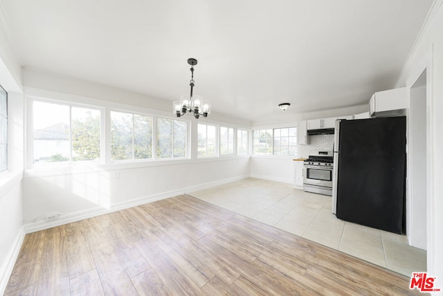 kitchen with white cabinets, a healthy amount of sunlight, light wood-type flooring, and appliances with stainless steel finishes