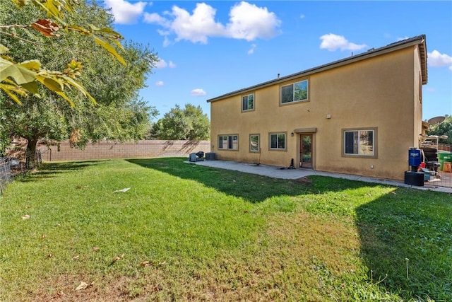 rear view of house featuring a lawn and a patio area