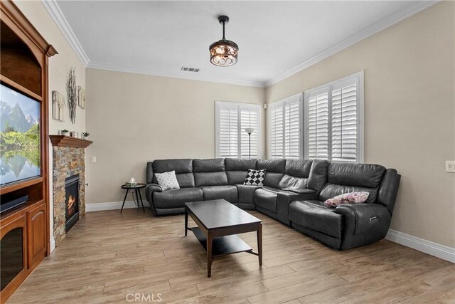 living room with crown molding, a fireplace, and light hardwood / wood-style floors