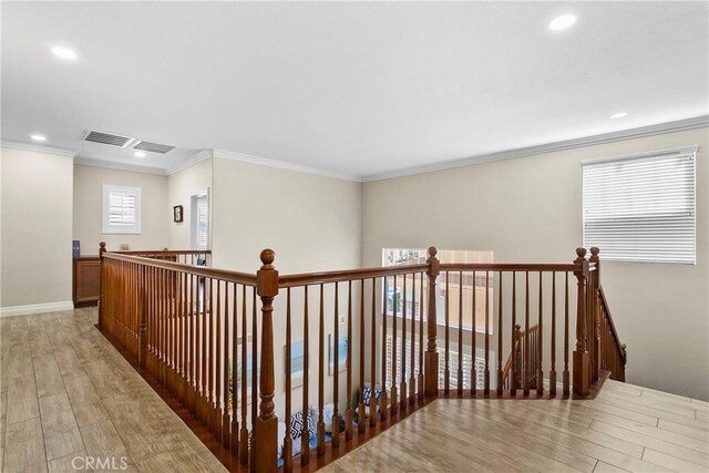 corridor featuring light wood-type flooring and ornamental molding