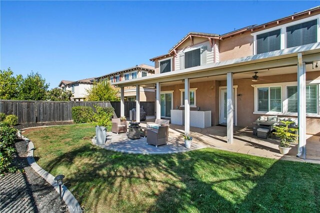 back of house featuring outdoor lounge area, ceiling fan, a yard, and a patio