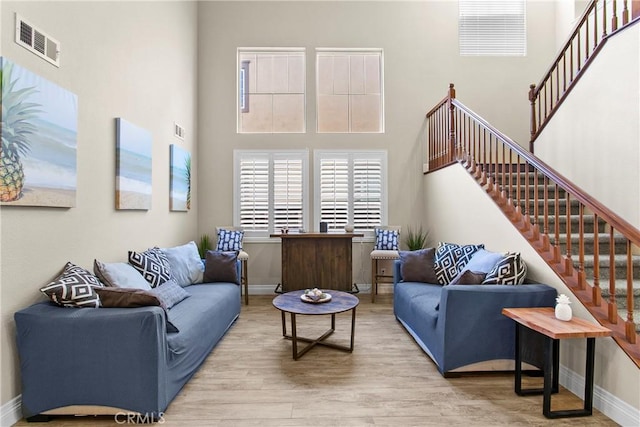 living room featuring a high ceiling and light wood-type flooring