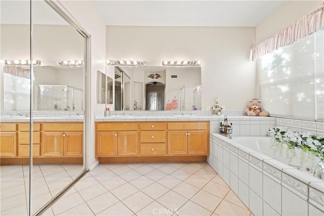 bathroom featuring tile patterned floors, vanity, and shower with separate bathtub