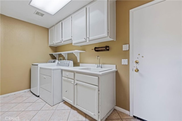 laundry area with cabinets, light tile patterned flooring, washing machine and dryer, and sink