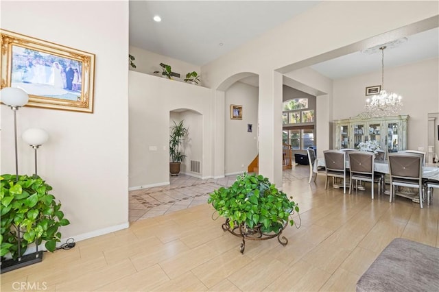 entryway with light wood-type flooring and a notable chandelier