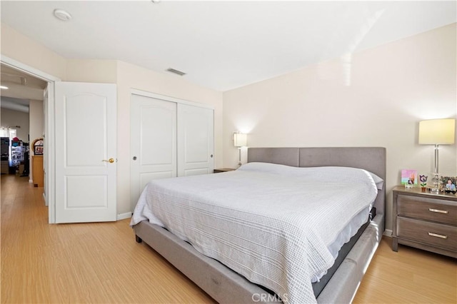 bedroom with light wood-type flooring and a closet