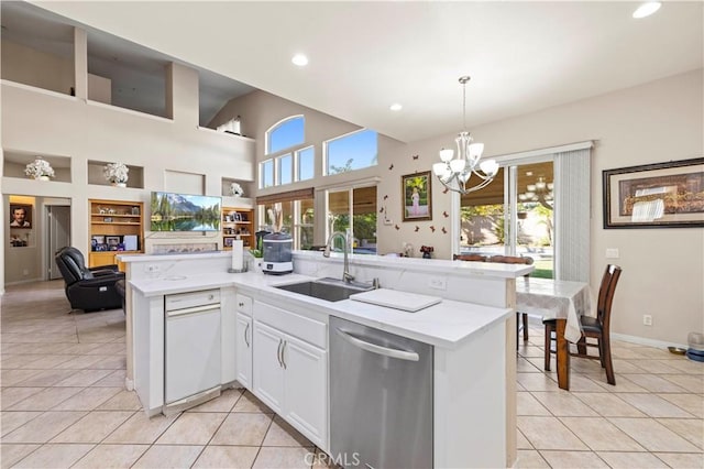 kitchen featuring sink, white cabinets, stainless steel dishwasher, decorative light fixtures, and light tile patterned flooring