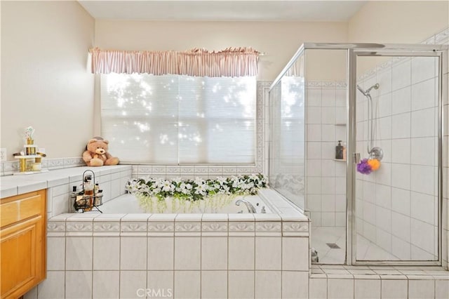 bathroom with vanity and shower with separate bathtub