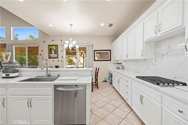 kitchen with appliances with stainless steel finishes, backsplash, sink, an inviting chandelier, and white cabinets