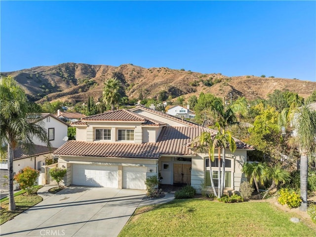 mediterranean / spanish house featuring a mountain view, a garage, and a front lawn