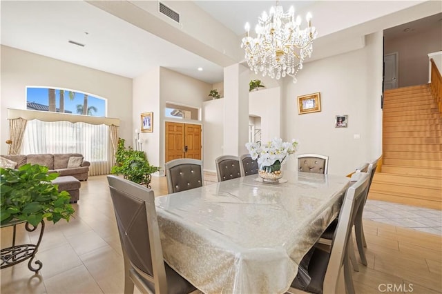 dining space with light tile patterned floors and an inviting chandelier