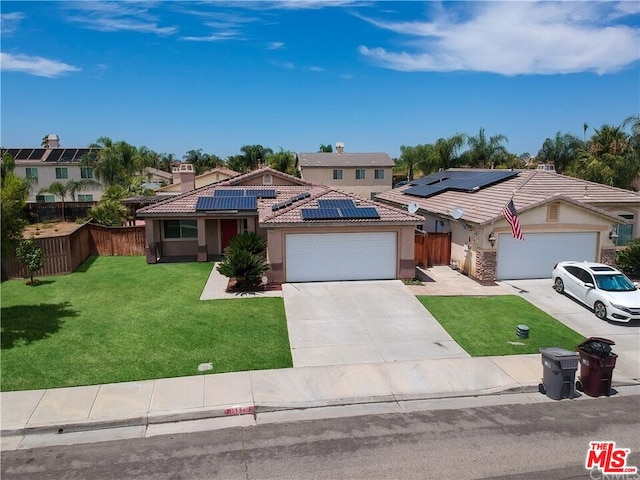 view of front of house with a garage, a front yard, and solar panels