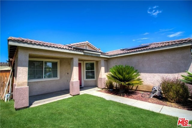 single story home featuring a front yard and solar panels