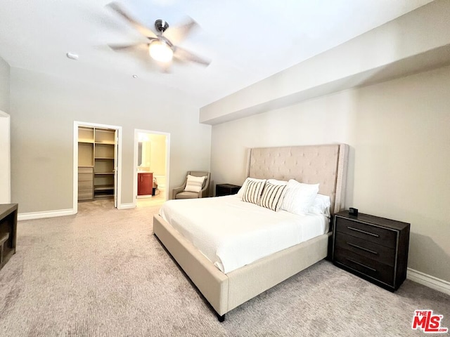 bedroom with a spacious closet, a closet, ceiling fan, and light carpet