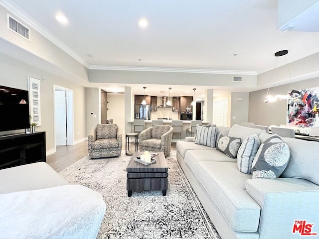 living room with light wood-type flooring and crown molding