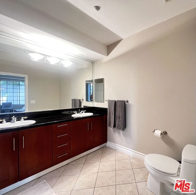 bathroom with tile patterned flooring, vanity, and toilet