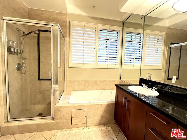 bathroom with tile patterned flooring, shower with separate bathtub, and vanity