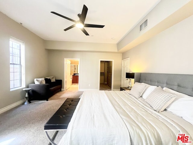 bedroom with light carpet, connected bathroom, a closet, and ceiling fan