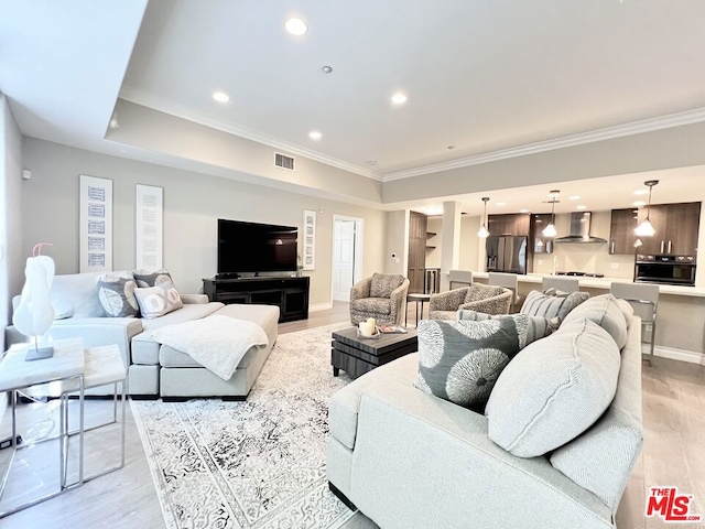 living room with crown molding and light hardwood / wood-style flooring