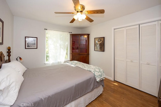 bedroom featuring ceiling fan, dark hardwood / wood-style flooring, and a closet