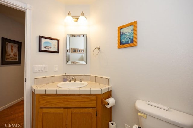 bathroom with hardwood / wood-style floors, vanity, and toilet