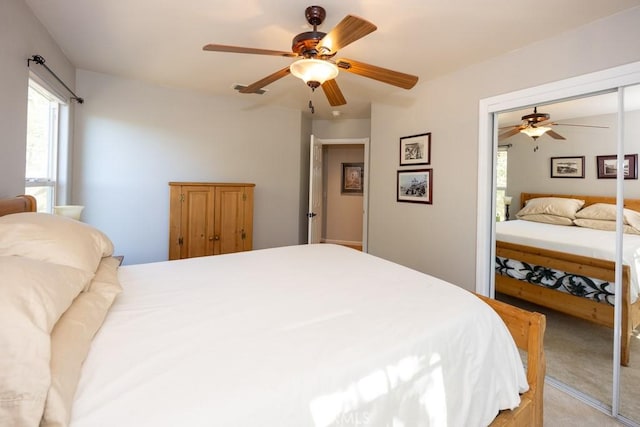 carpeted bedroom with ceiling fan and a closet