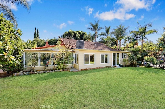 back of house featuring a lawn