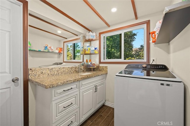 laundry area with dark hardwood / wood-style flooring, sink, and cabinets