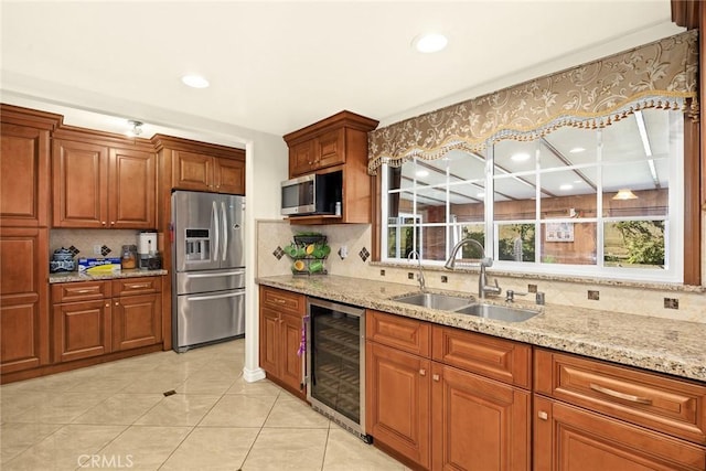 kitchen featuring decorative backsplash, appliances with stainless steel finishes, beverage cooler, and sink