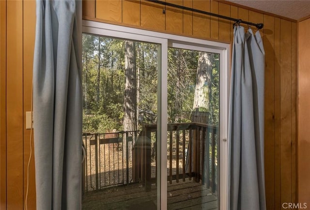 doorway to outside featuring wood walls