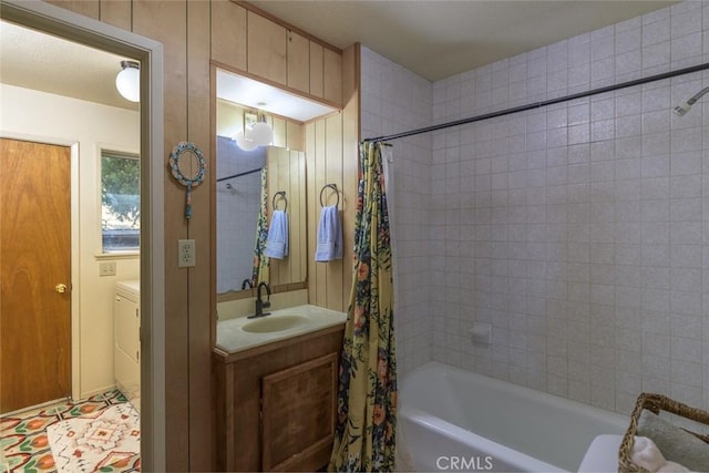 bathroom with a textured ceiling, vanity, shower / bath combo, and washer / clothes dryer