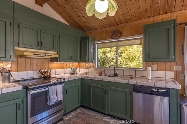 kitchen featuring tile countertops, sink, green cabinetry, vaulted ceiling, and appliances with stainless steel finishes