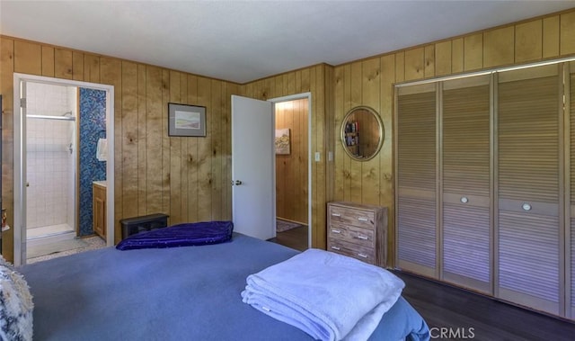 bedroom featuring dark wood-type flooring, wooden walls, and a closet